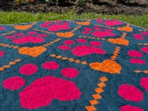 Paw Prints on My Heart Quilt laying flat in the grass.
